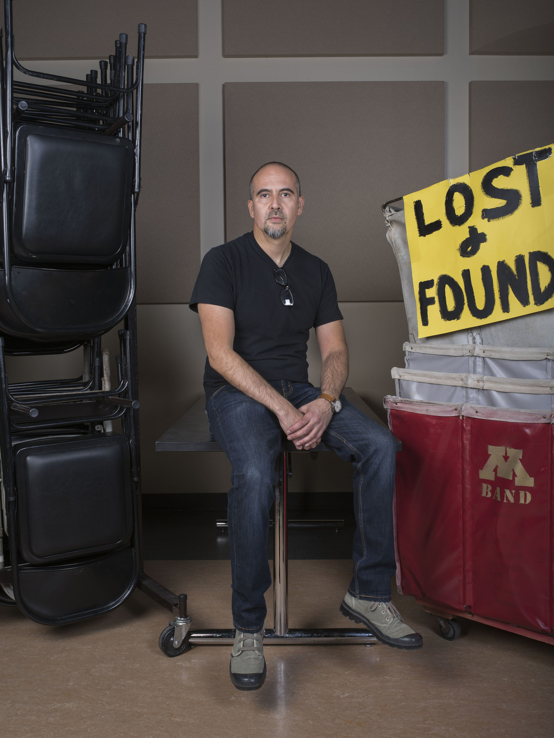 Man sitting on table next to bins with lost and found sign