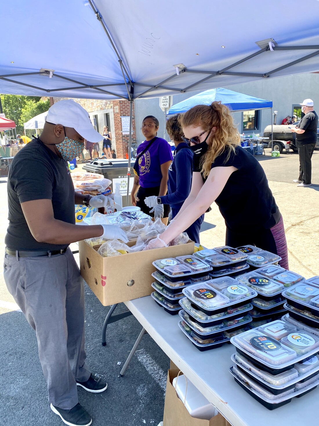 Two people getting meals ready for distribution