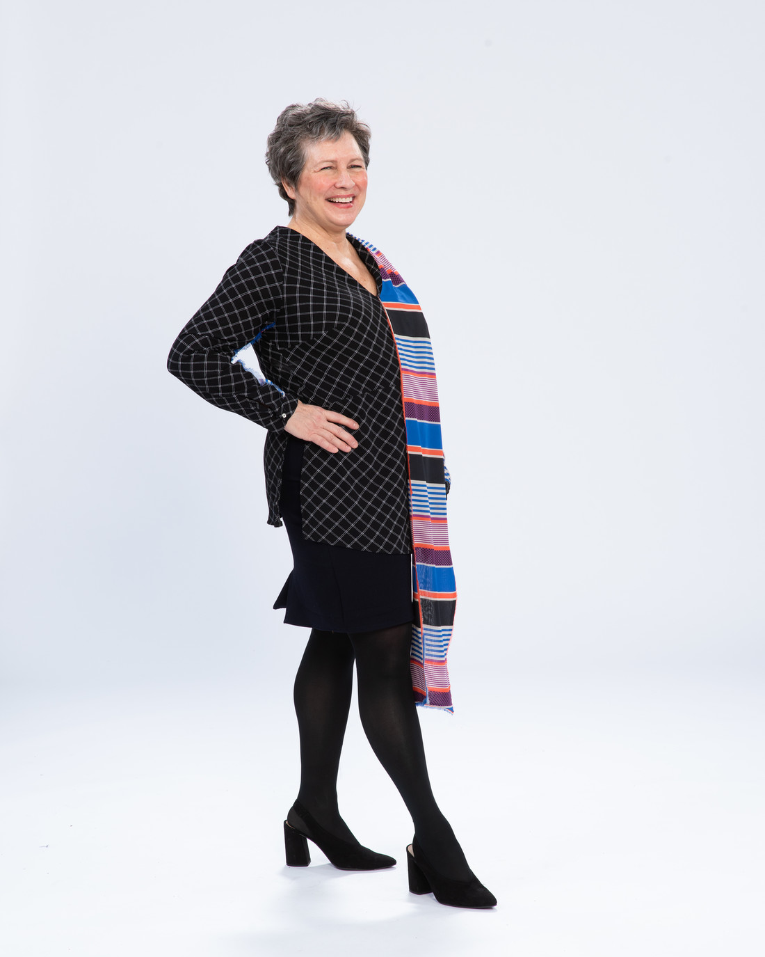 Woman wearing a black dress and a brightly striped scarf