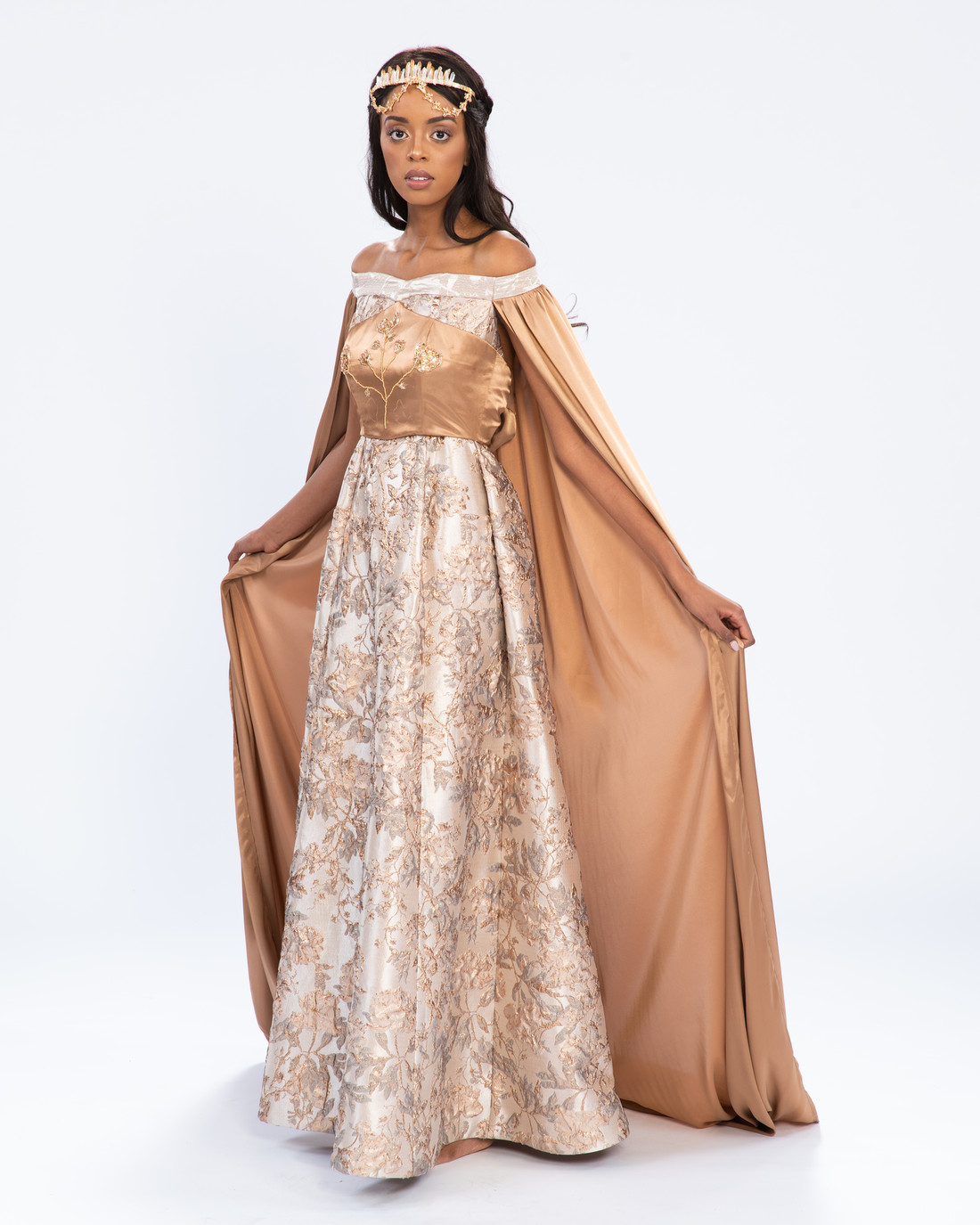 Woman wearing long gold dress with cape