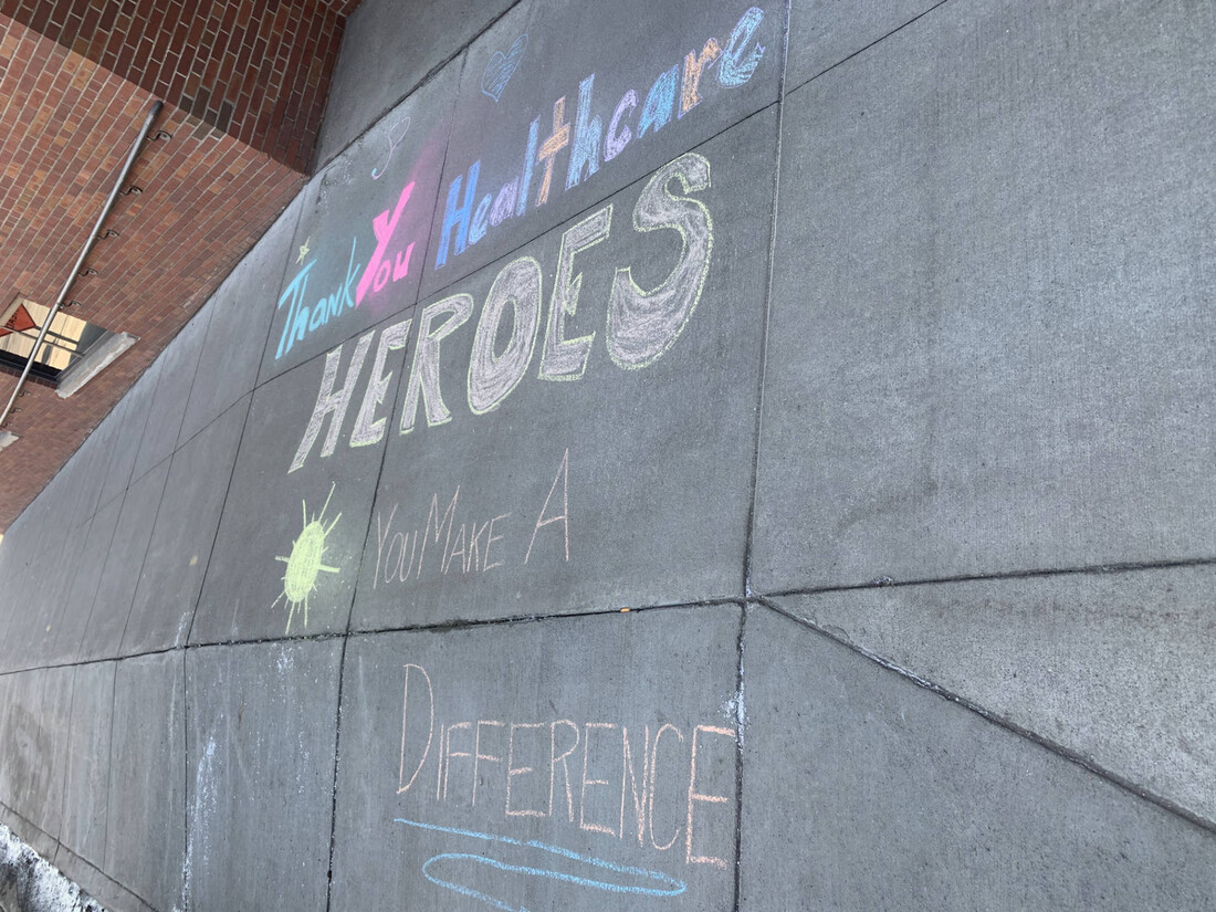Chalk drawing on sidewalk that reads: Thank you health care heros. You make a difference. 
