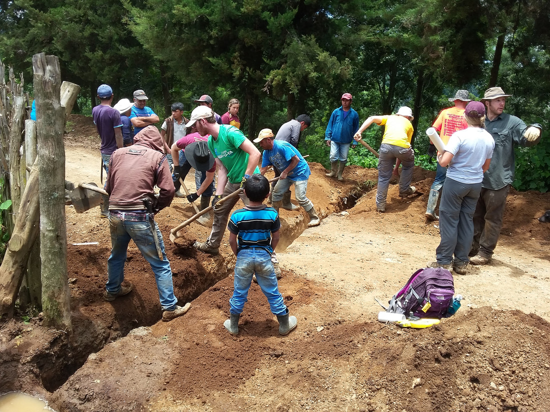 Photo of students and residents of Xiquin Sanahi, Guatemala, installing water distribution pipelines